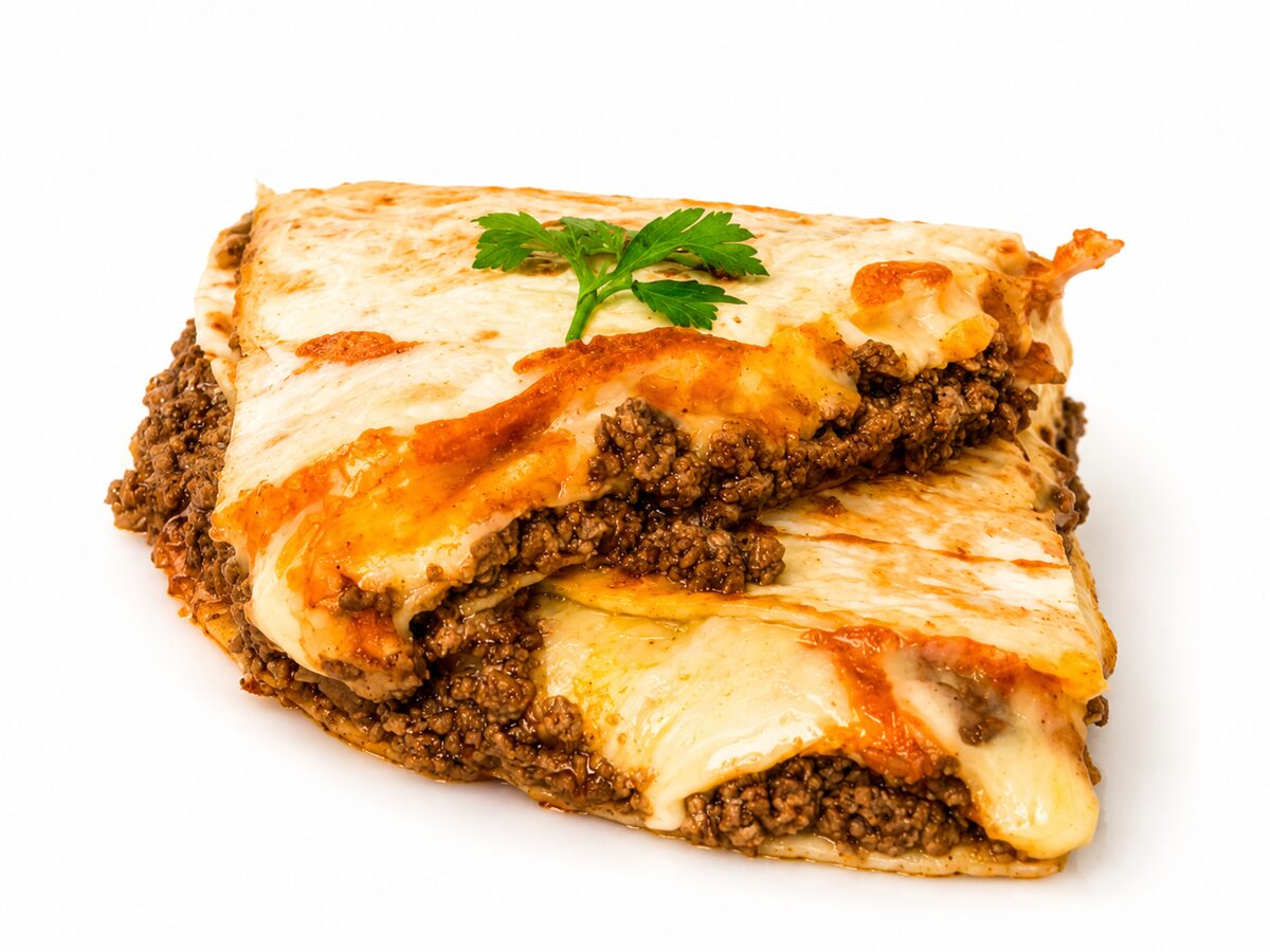Golden folded quesadilla overflowing with seasoned beef and melted cheese